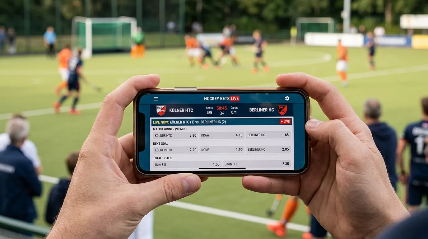 Smartphone-Display mit Feldhockey-Wetten-App und Live-Quoten auf dem Spielfeld